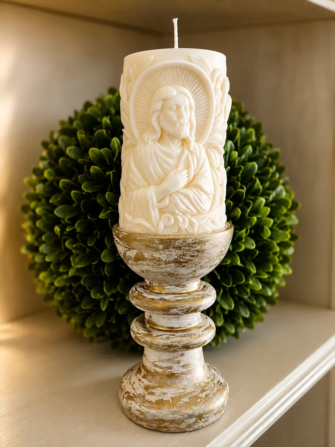 Sacred Heart pillar candle styled with greenery and a distressed gold pedestal